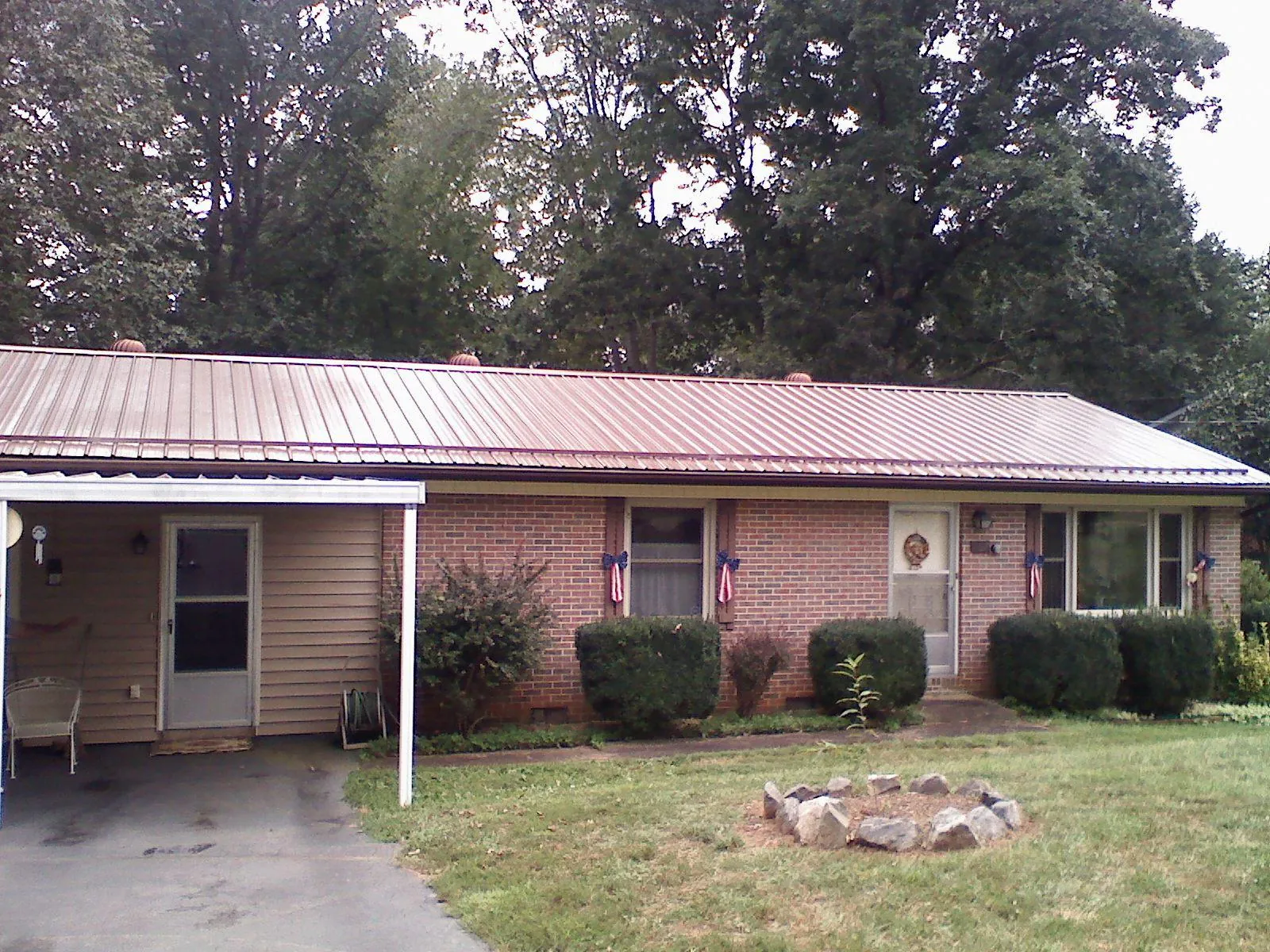 Bronze metal roof and carport on a brick ranch home — Roof Repair work by our crew in Lithia